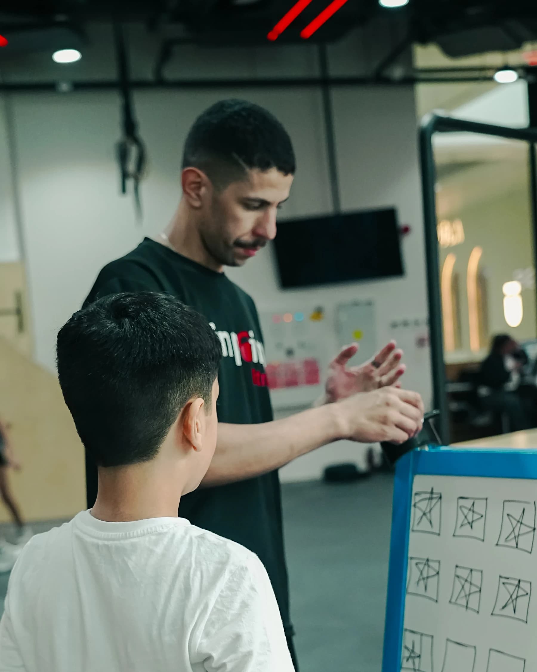A Pinpoint Fitness coach guiding a student through a hand-signal exercise